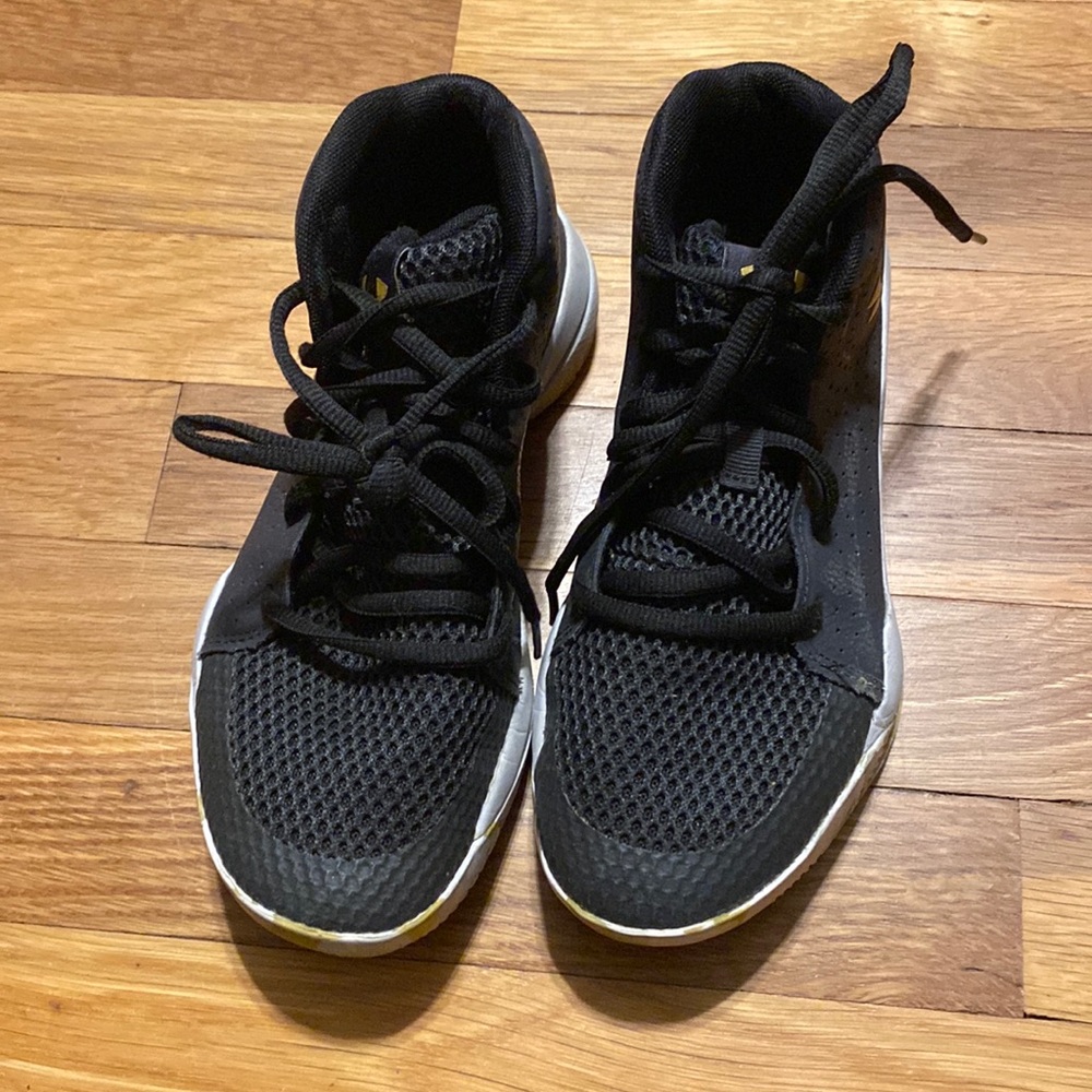 Black and gold Under Armour basketball shoes.